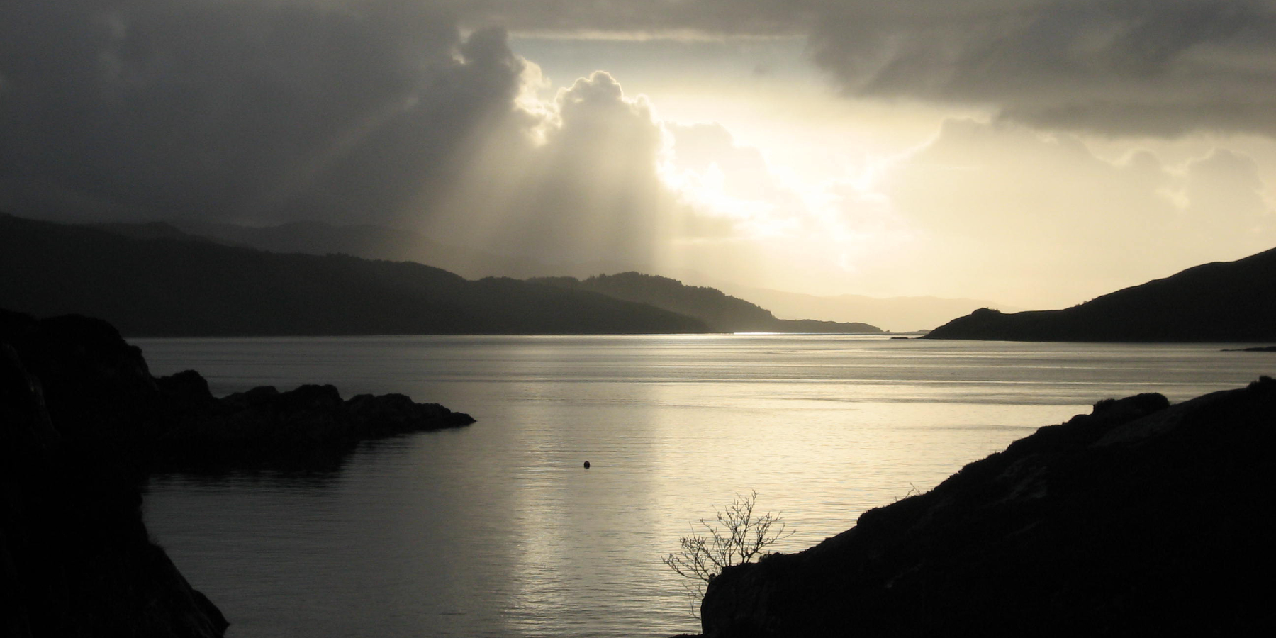 sunbeams and clouds over a still sound of sleat
